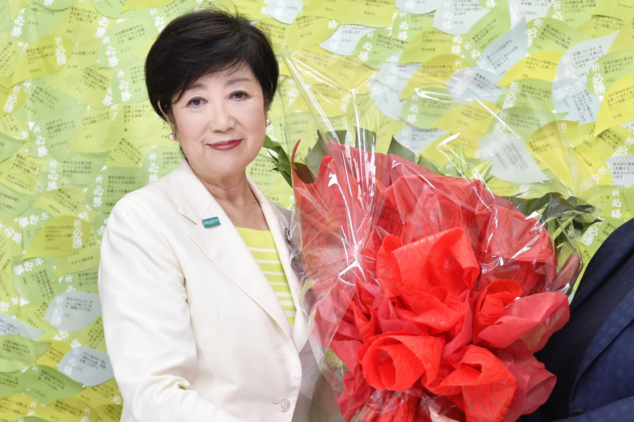 고이케 유리코(小池百合子·67) 도쿄도지사가 당선이 확정된 후 축하 꽃다발을 들고 있는 모습. [AP]