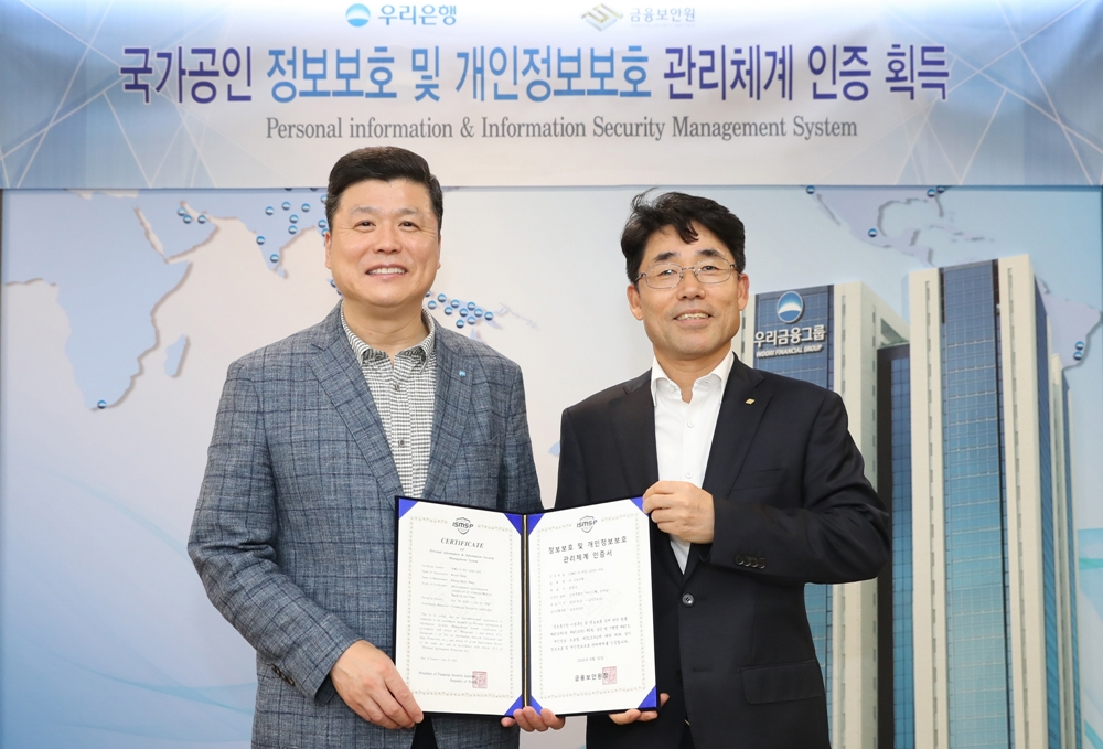 지난 1일 서울 중구 우리은행 본점에서 열린 정보보호 및 개인정보보호 관리체계 인증서 수여식에서 권광석(왼쪽) 우리은행장과 김영기 금융보안원장이 기념촬영을 하고 있다. [우리은행 제공]