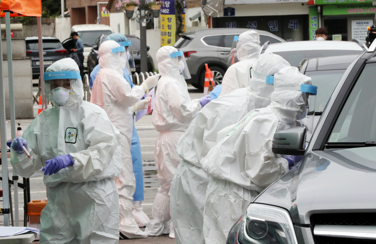 어린이집 원생 남매 2명이 코로나19 확진 판정을 받은 가운데 6일 오전 광주 동구청 주차장에 마련된 임시 드라이브스루 선별진료소에서 동구보건소 직원들이 확진자가 나온 어린이집 원생들과 가족들을 대상으로 검체를 채취하고 있다. [연합]