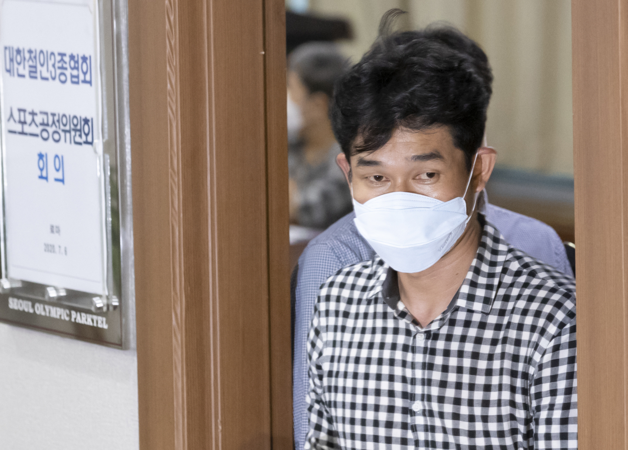 고 최숙현 선수 사망 사건과 관련해 6일 오후 서울 송파구 올림픽파크텔에서 열린 대한철인3종협회 스포츠공정위원회에서 가해자로 지목된 경주 트라이애슬론 김 모 감독이 소명을 마친 후 회의장에서 나서고 있다. [연합]