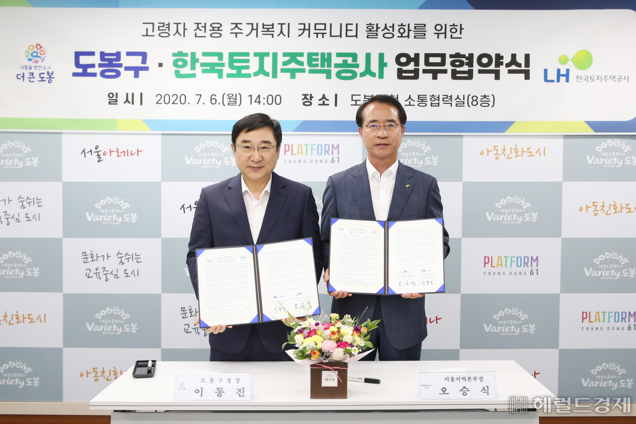 이동진 도봉구청장(왼쪽)이 한국토지주택공사 오승식서울지역본부장(오른쪽)과 업무협약 후 기념 사진을 찍고 있다.