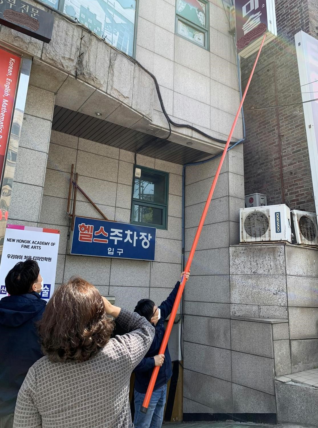 구청 공무원들이 건물 외벽에 붙은 간판이 안전한 지 점검하고 있다. [서대문구 제공]