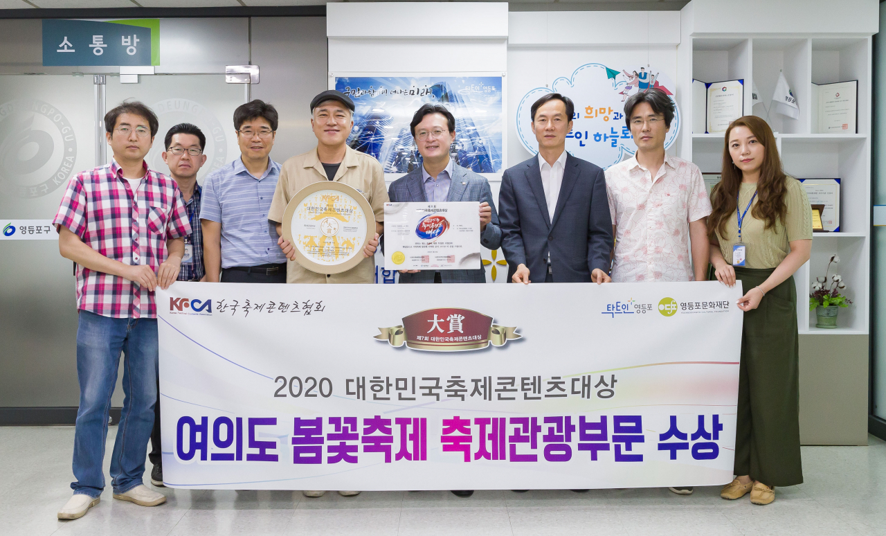 채현일 구청장(왼쪽에서 다섯번째)과 직원들이 여의도 봄꽃축제의 대한민국축제콘텐츠 대상 수상을 기념하고 있다. [영등포구 제공]