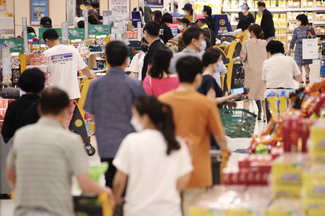South Korean consumers shop at a local retailer in Seoul on Sunday. (Yonhap)