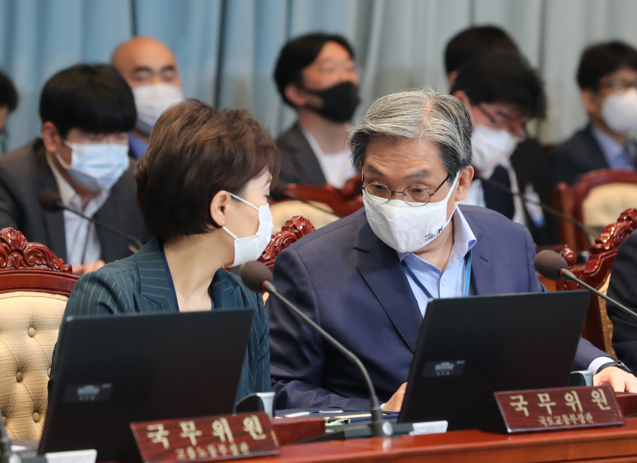 President Moon Jae-in's chief of staff Noh Young-min (right) speaks with Minister of Land, Infrastructure and Transport Kim Hyun-mee at a Cabinet meeting. (Yonhap)