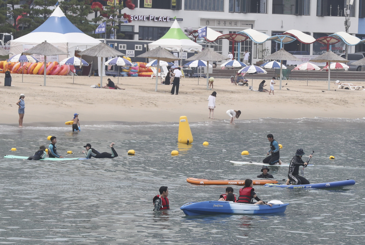 무더운 날씨를 보인 8일 오후 부산 광안리 해수욕장에서 시민들이 해양스포츠를 체험하며 더위를 식히고 있다. [연합]