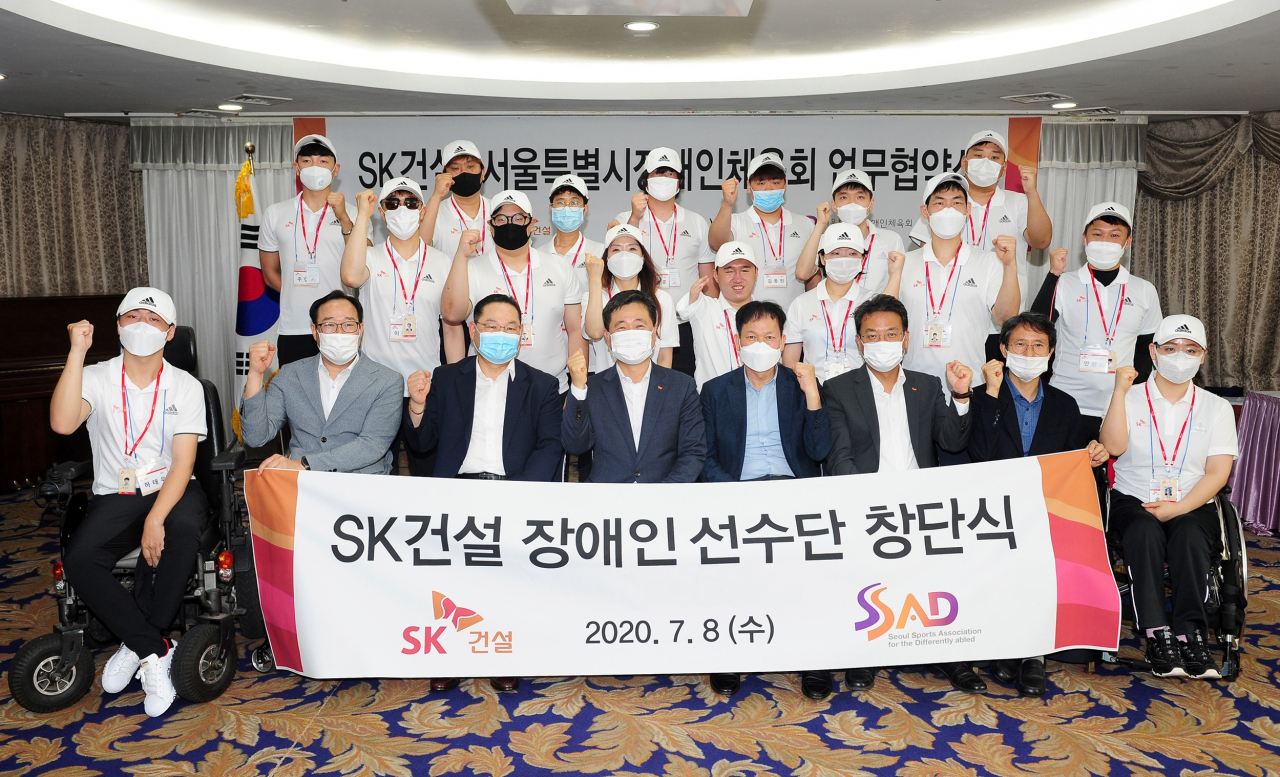 임영문 SK건설 사장(첫째줄 왼쪽 네번째), 김종덕 서울시장애인체육회 부회장(첫째줄 왼쪽 세번째), 김태양 한국장애인고용공단 서울동부지사장(첫째줄 왼쪽 다섯번째), SK건설 장애인 체육선수 16명 등 관계자들이 행사를 마치고 기념촬영을 하고 있다[SK건설 제공]