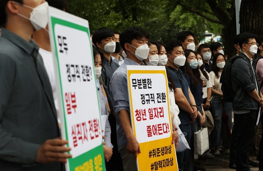 인천국제공항공사노동조합 소속 조합원들이 지난달 25일 오후 서울 청와대 인근에서 열린 기자회견에서 비정규직 보안검색 요원들의 정규직 전환 관련 입장을 발표하며 손팻말을 들고 있다. [연합뉴스]
