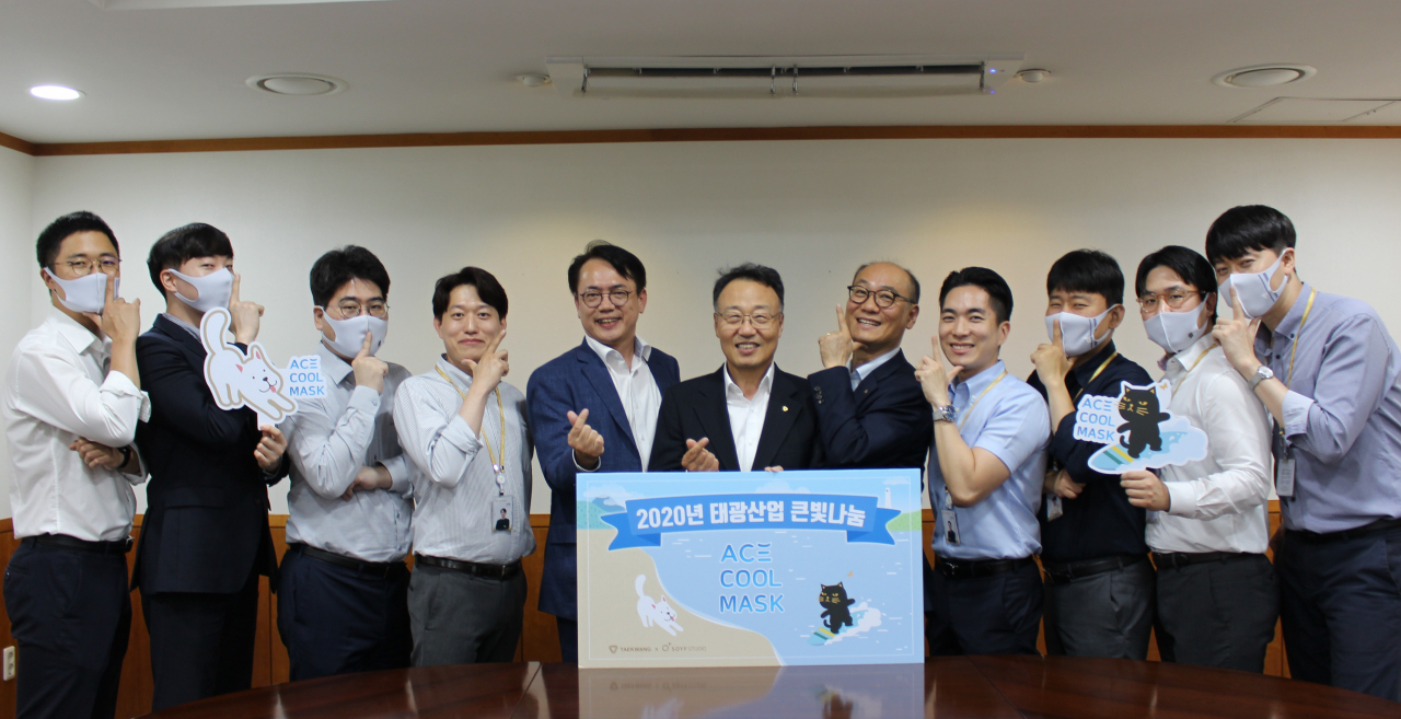 태광산업 임직원들이 '태광산업 큰빛나눔' 크라우드펀딩 론칭을 기념해 펀딩제품인 '에이스 쿨 마스크'를 끼고 사진 촬영을 하고 있다. 오른쪽에서 여섯번째 태광산업 석유화학사업본부 홍현민 대표, 일곱번째 태광산업 섬유사업본부 박재용 대표. [태광산업 제공]