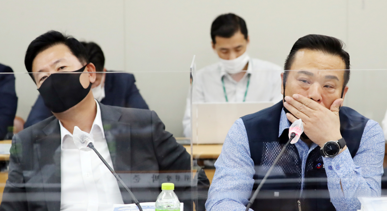 7일 오후 세종시 정부세종청사 고용노동부에서 열린 제5차 최저임금위원회 전원회의에 참석한 사용자 위원인 류기정 한국경영자총협회 전무(왼쪽)과 근로자 위원인 이동호 한국노총 사무총장이 서로 다른 곳을 응시하고 있다. [연합]