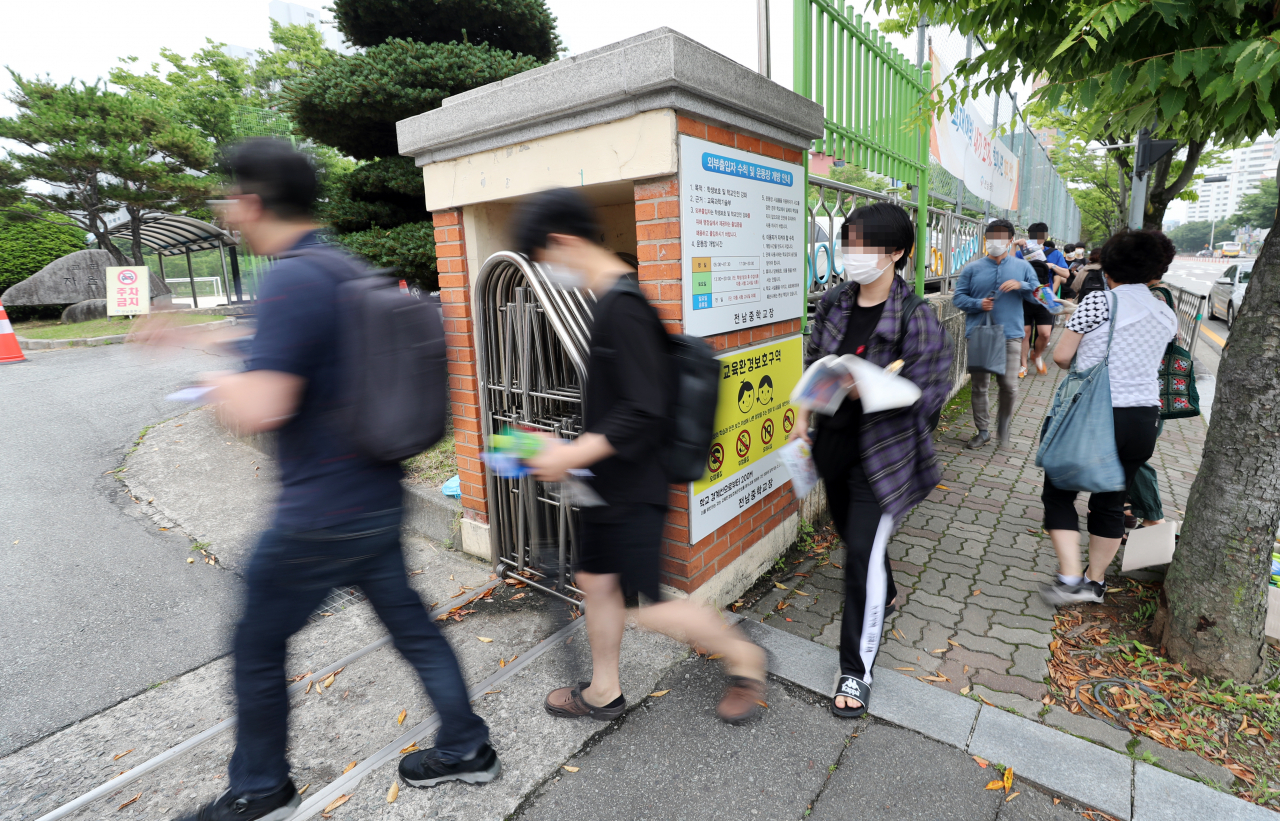 11일 오전 광주 서구의 한 중학교에 마련된 국가직 공무원 9급 필기시험장에 수험생들의 발길이 이어지고 있다. 최근 코로나19 확산세가 이어진 광주에서는 이날 1만2천121명이 지원한 국가직 공무원 9급 필기시험이 27개 시험장, 654개 시험실에서 치러진다. [연합]