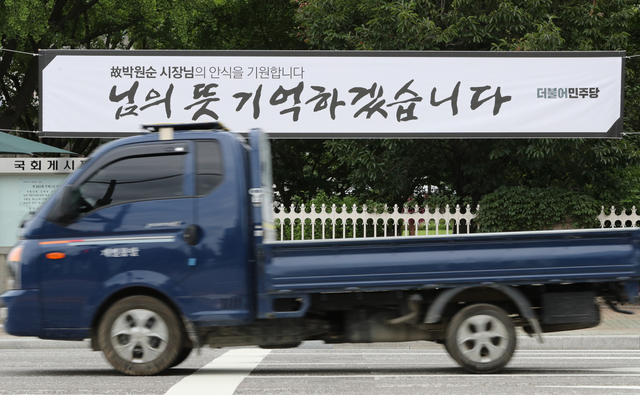 12일 서울 여의도 국회 앞에 더불어민주당 명의의 고 박원순 서울시장 추모 플래카드가 걸려 있다. 연합뉴스