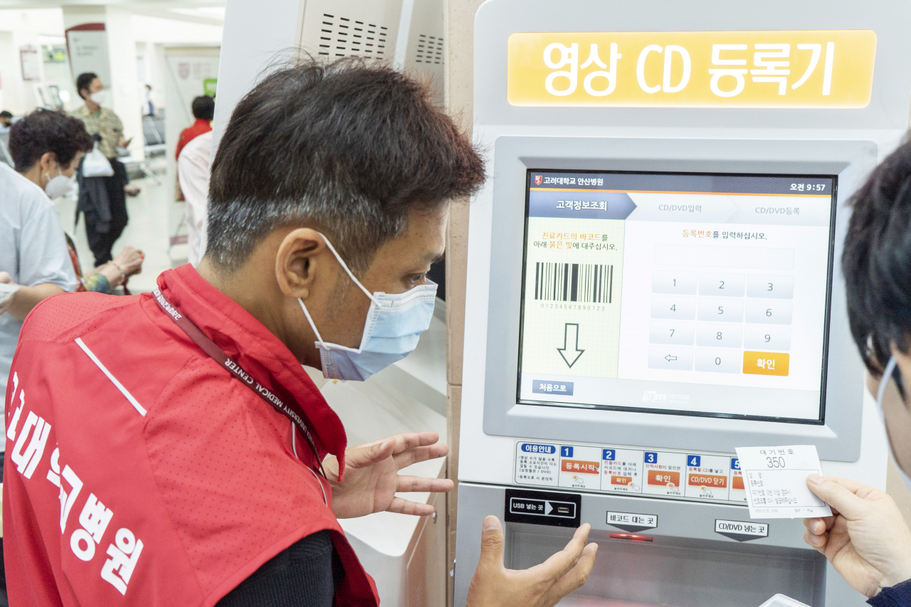 최근 장애인 채용으로 입사한 이 모씨가 내원한 환자에게 검사영상 등록방법을 설명하고 있다. 고려대의료원 제공