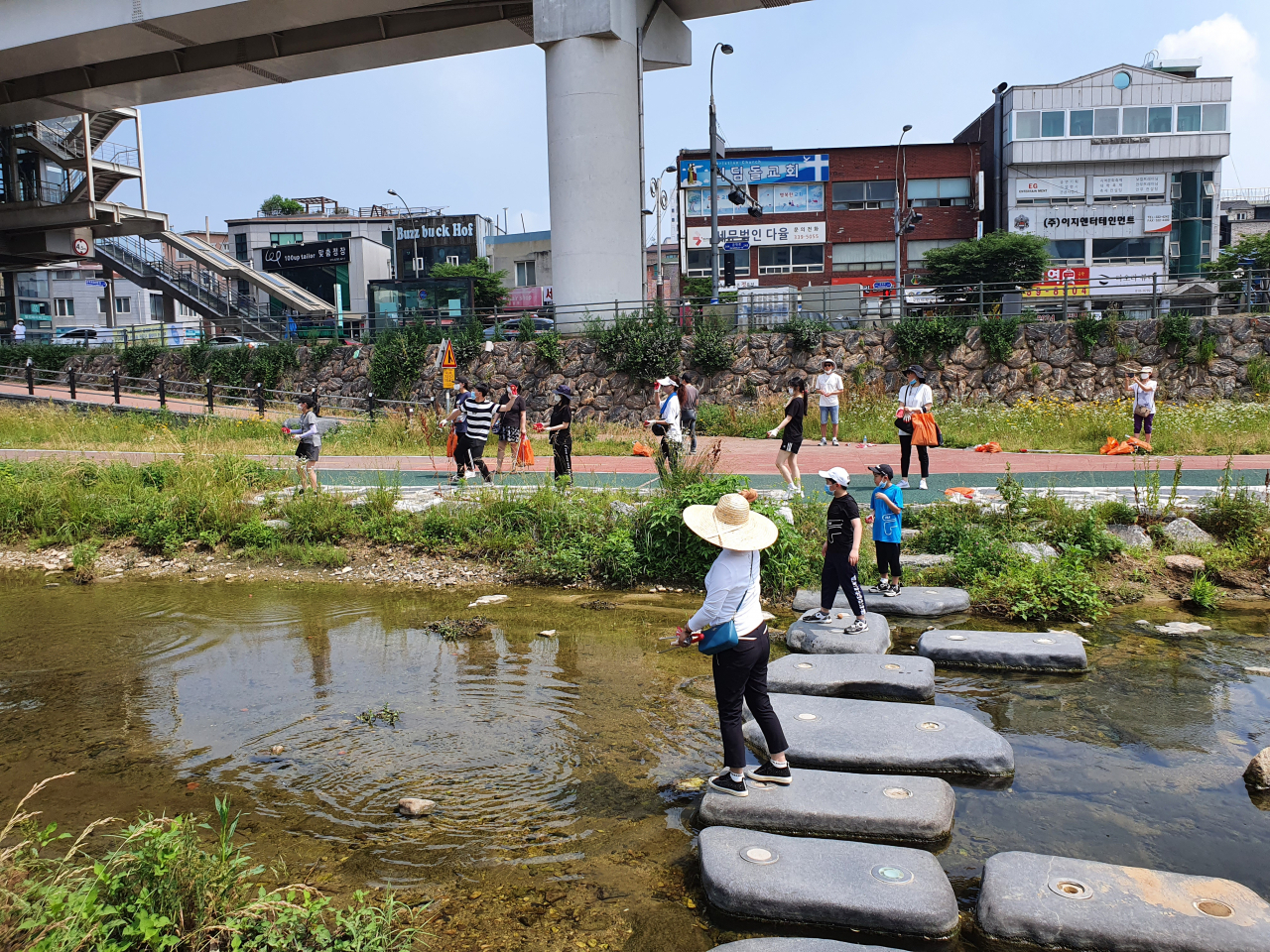 용인 크리스토퍼 회원들이 시에서 EM흙공을 지원받아 수질정화 활동을 하고 있다. [용인시 제공]