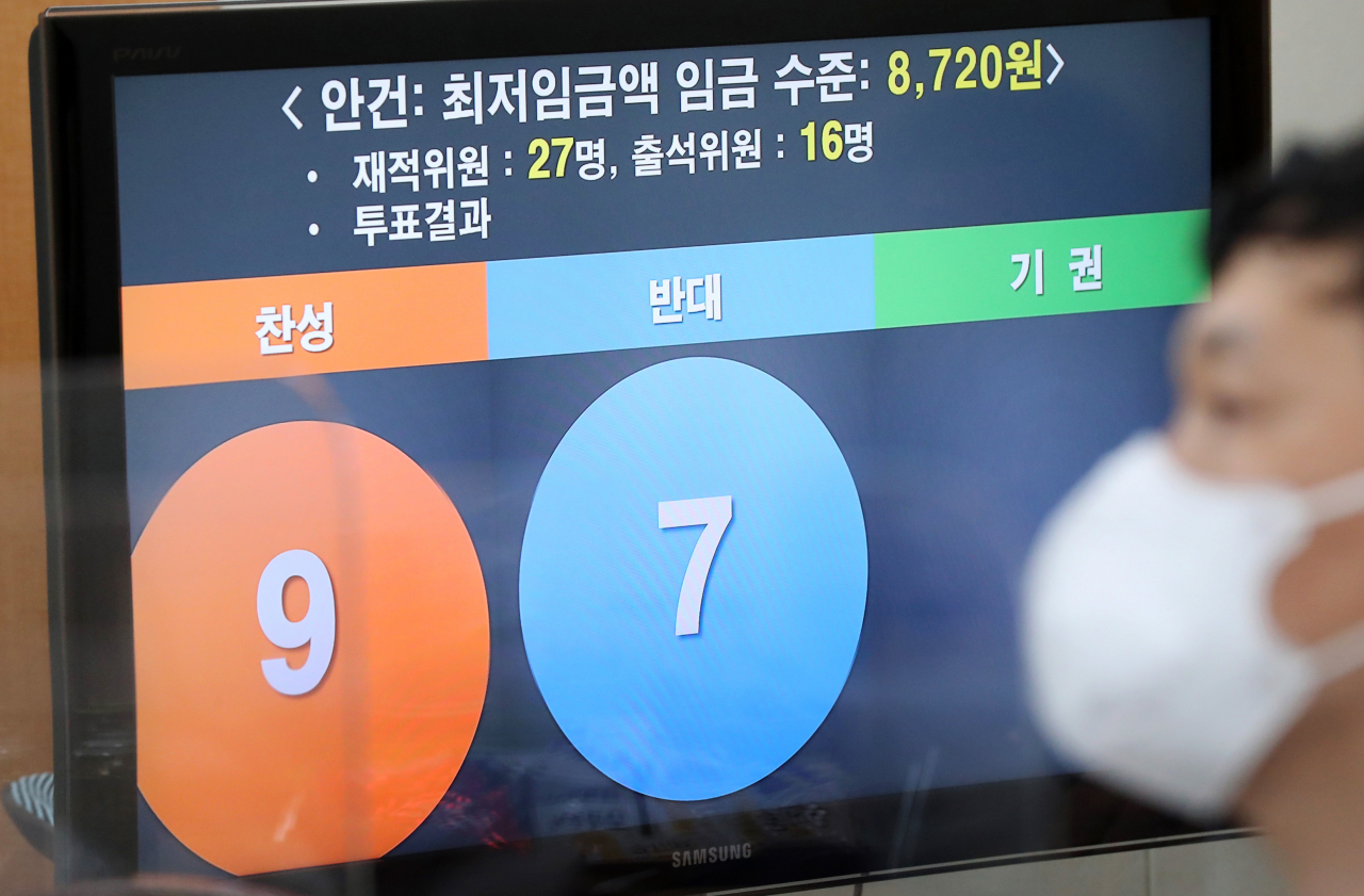 14일 새벽 세종시 정부세종청사 고용노동부에서 열린 제9차 최저임금위원회 전원회의 결과 브리핑을 취재진이 경청하고 있다. 이날 전원회의는 근로자위원들의 집단 퇴장으로 공익위원들이 낸 안으로 표결에 부쳐졌다. 찬성 9표, 반대 7표로 채택된 내년도 최저임금은 시급 기준 8720원으로 최종 의결됐다. [연합]