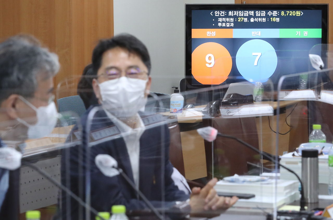 박준식 최저임금위원장(왼쪽 두번째)이 14일 새벽 세종시 정부세종청사 고용노동부에서 열린 제9차 최저임금위원회 전원회의를 마친 뒤 기자회견을 준비하고 있다. 이날 전원회의는 근로자위원들의 집단 퇴장으로 공익위원들이 낸 안으로 표결에 부쳐졌다. 찬성 9표, 반대 7표로 채택된 내년도 최저임금은 시급 기준 8720원으로 최종 의결됐다. [연합]