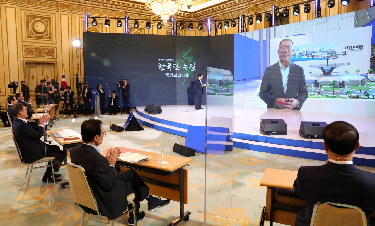 문재인 대통령이 14일 청와대 영빈관에서 열린 '한국판 뉴딜 국민보고대회'에서 실시간 화상으로 연결된 정의선 현대차그룹 수석부회장의 그린 뉴딜 관련 발언을 듣고 있다. [연합]
