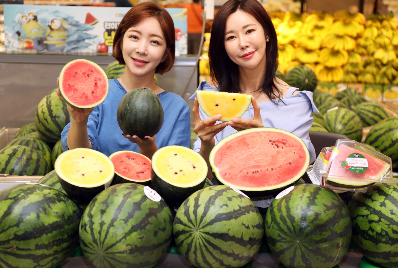 1~2인 가구도 부담 없이 즐길 수 있는 미니 수박과 자른 수박을 소개하는 모델들. [제공=이마트]