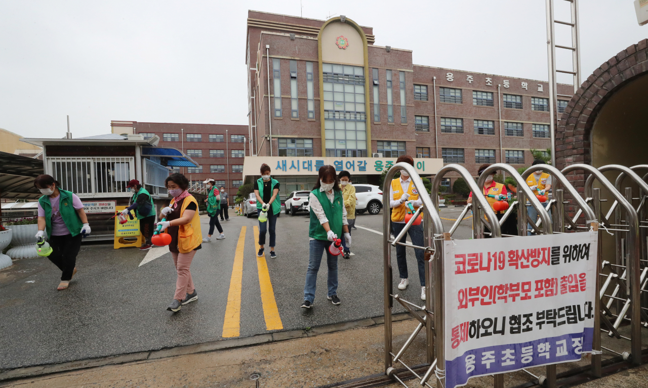 지난 6일 오전 광주 북구의 한 초등학교에서 동행정복지센터 직원들과 봉사단체 회원들이 방역하고 있다. 광주시교육청은 초등학생 확진자가 나오자 광주 북구의 유치원과 초·중·고교 전체에 12일까지 등교 중지와 함께 원격수업을 하기로 했다. [연합]