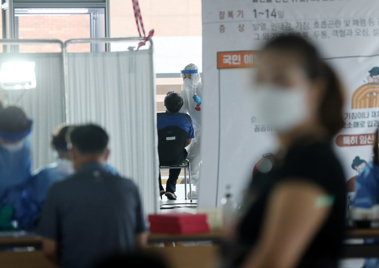 14일 오전 광주 북구보건소 선별진료소에서 보건소 직원들이 검체를 채취하고 있다. [연합]