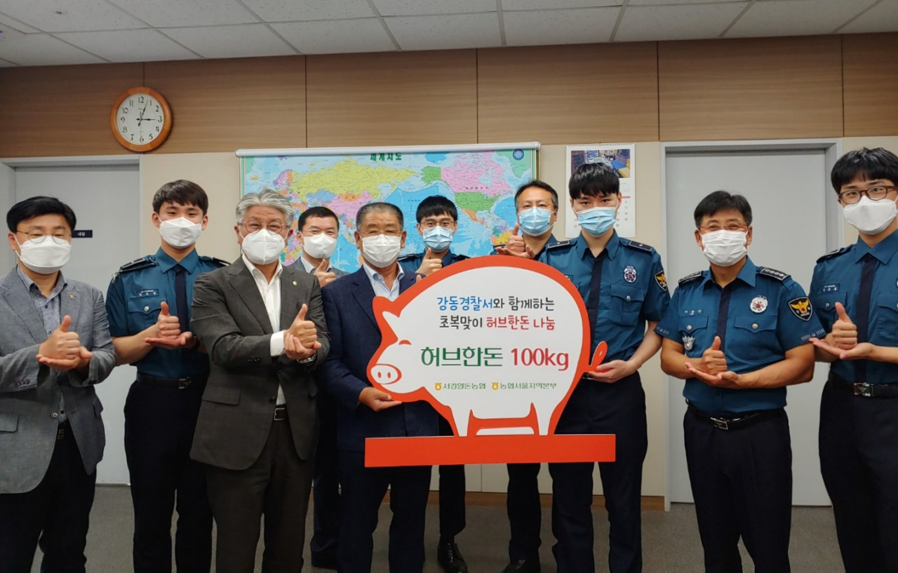 이대엽 농협중앙회 서울지역본부장왼쪽에서 세번째), 이정배 서경양돈농협 조합장(왼쪽 에서 다섯번째)이 초복(16일)을 앞두고 ‘우리농축산물 행복나눔상자'를 이을신 서울 강동경찰서장(오른쪽에서 두번째)에게 전달한 뒤 관계자들과 기념촬영을 하고 있다. [농협 제공]