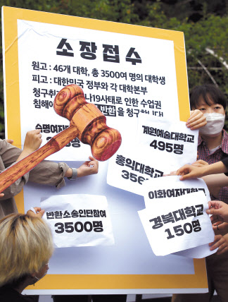 지난 1일 서울 서초구 서울중앙지방법원 앞에서 열린 전국 42개 대학 3500명 대학생 등록금 반환 집단 소송 선포 기자회견에 참석한 대학생들이 소장 접수 패널에 각 학교별 소송 참여 학생수가 적힌 종이를 부착하는 상징의식을 펼치고 있다. [연합]