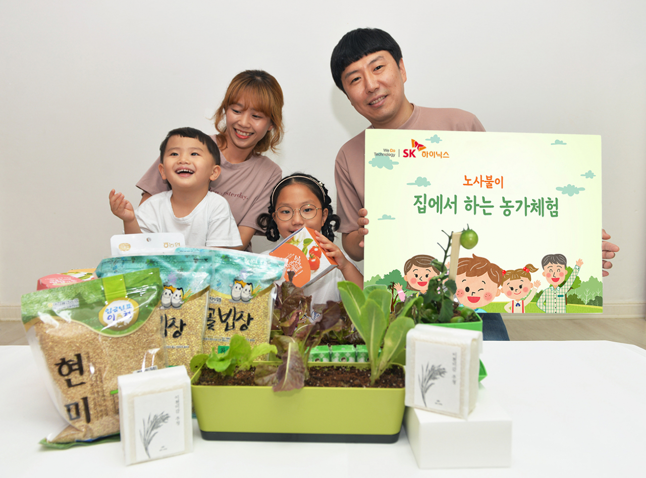 SK하이닉스 장윤숙 기장(이천FAB제조팀) 가족이 노사불이 '집에서 하는 농가 체험 박스'를 전달받고 환하게 웃고 있다. [SK하이닉스 제공]