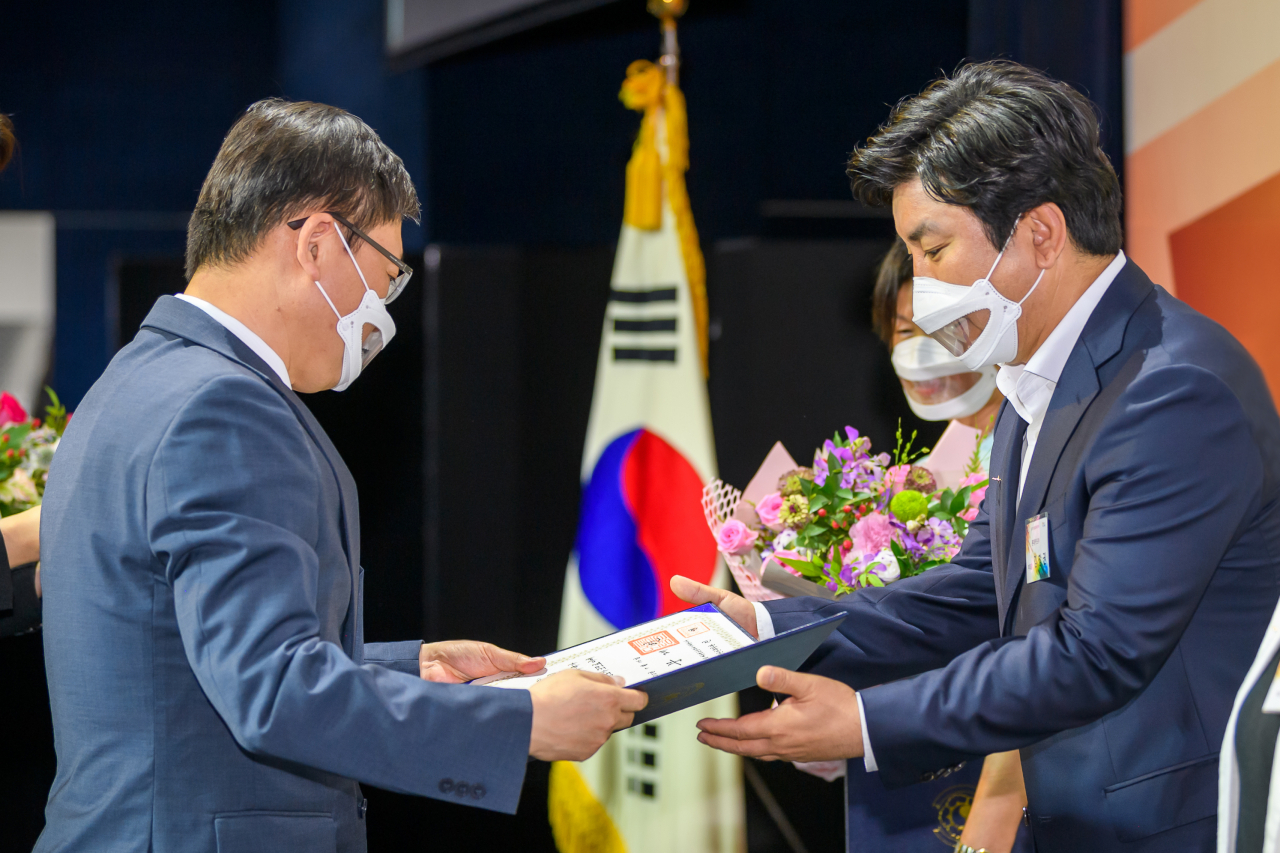16일 JW 메리어트 호텔 서울에서 열린 2020년 장애인 고용촉진 대회에서 김창권 롯데카드 부회장이 장애인 고용촉진 유공자로 선정돼 최문석 롯데카드 경영지원부문장(오른쪽)이 대통령 표창을 대리 수상하고 있다.[롯데카드 제공]