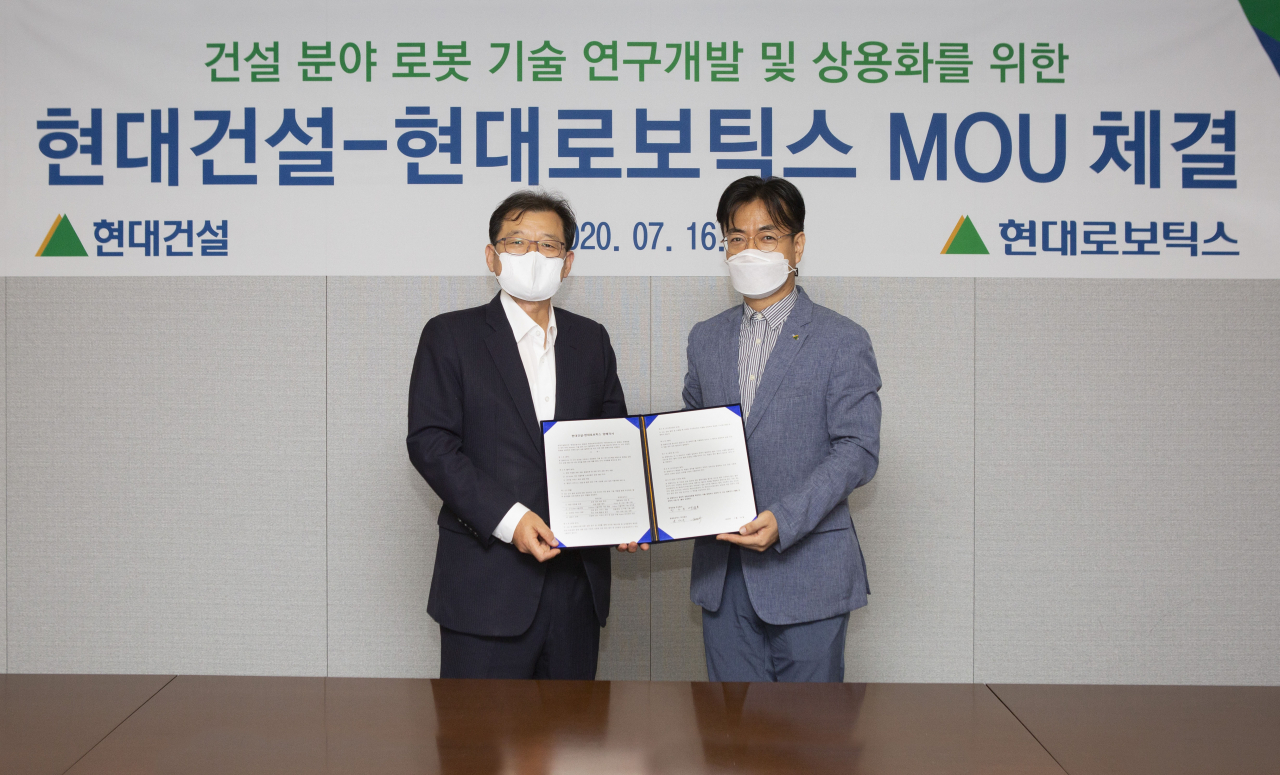 서울 종로구 계동 현대빌딩에서 현대건설 박구용 기술연구소장(왼쪽)과 현대로보틱스 윤대규 로봇연구소장이 건설 로보틱스 분야 연구협력에 대한 양해각서(MOU)들고 기념촬영을 하고 있다.