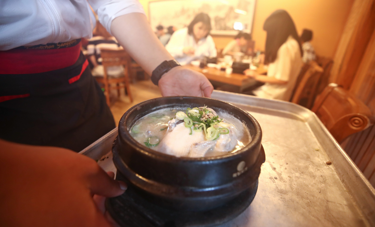 초복인 16일 서울 종로구의 한 삼계탕 전문점 앞[에서 직원들이 삼계탕을 나르고 있다. [연합뉴스]