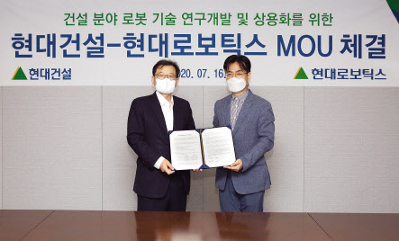 서울 종로구 계동 현대빌딩에서 현대건설 박구용 기술연구소장(왼쪽)과 현대로보틱스 윤대규 로봇연구소장이 건설 로보틱스 분야 연구협력에 대한 양해각서(MOU)들고 기념촬영을 하고 있다. [현대건설 제공]