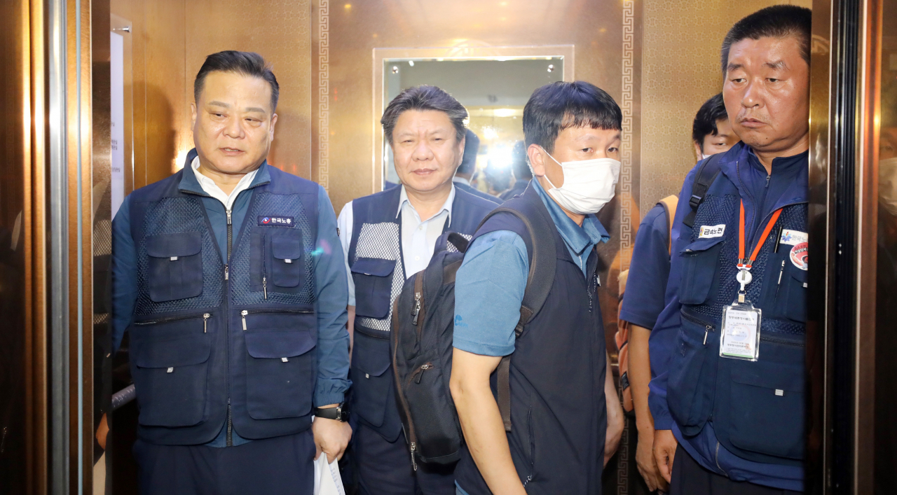 근로자 위원인 이동호 한국노총 사무총장(왼쪽)과 한국노총 소속 근로자위원들이 14일 새벽 세종시 정부세종청사 고용노동부에서 열린 제9차 최저임금위원회 전원회의에서 공익위원들의 1.5% 인상안 제시에 집단 퇴장을 선언한 뒤 청사 밖으로 이동하고 있다. [연합]