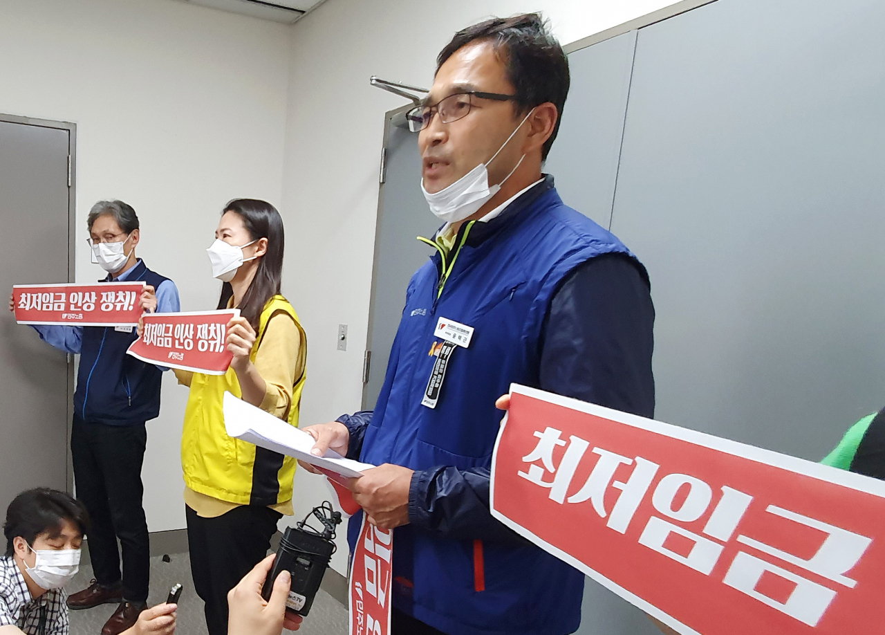 최저임금위원회 근로자위원인 윤택근 민주노총 부위원장(가운데)과 소속 위원들이 지난 13일 오후 제8차 최저임금위원회 전원 회의가 열리는 세종시 정부세종청사 고용노동부에서 기자회견을 열고 경영계의 최저임금 삭감안 요구 등과 관련해 입장 설명을 하고 있다. [연합]