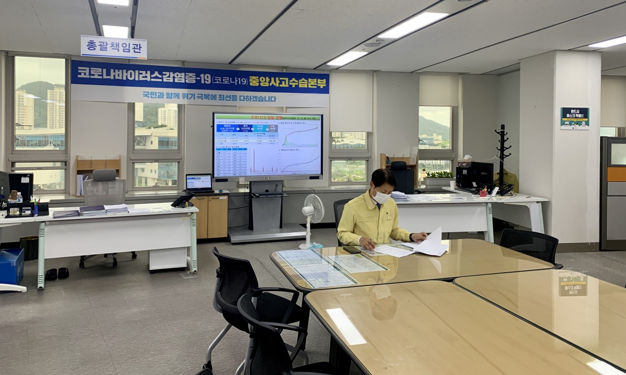 Vice Minister of Health and Welfare Kim Gang-lip perusing coronavirus documents at the Central Disaster Management Headquarters on Monday. (Kim Arin/The Korea Herald)