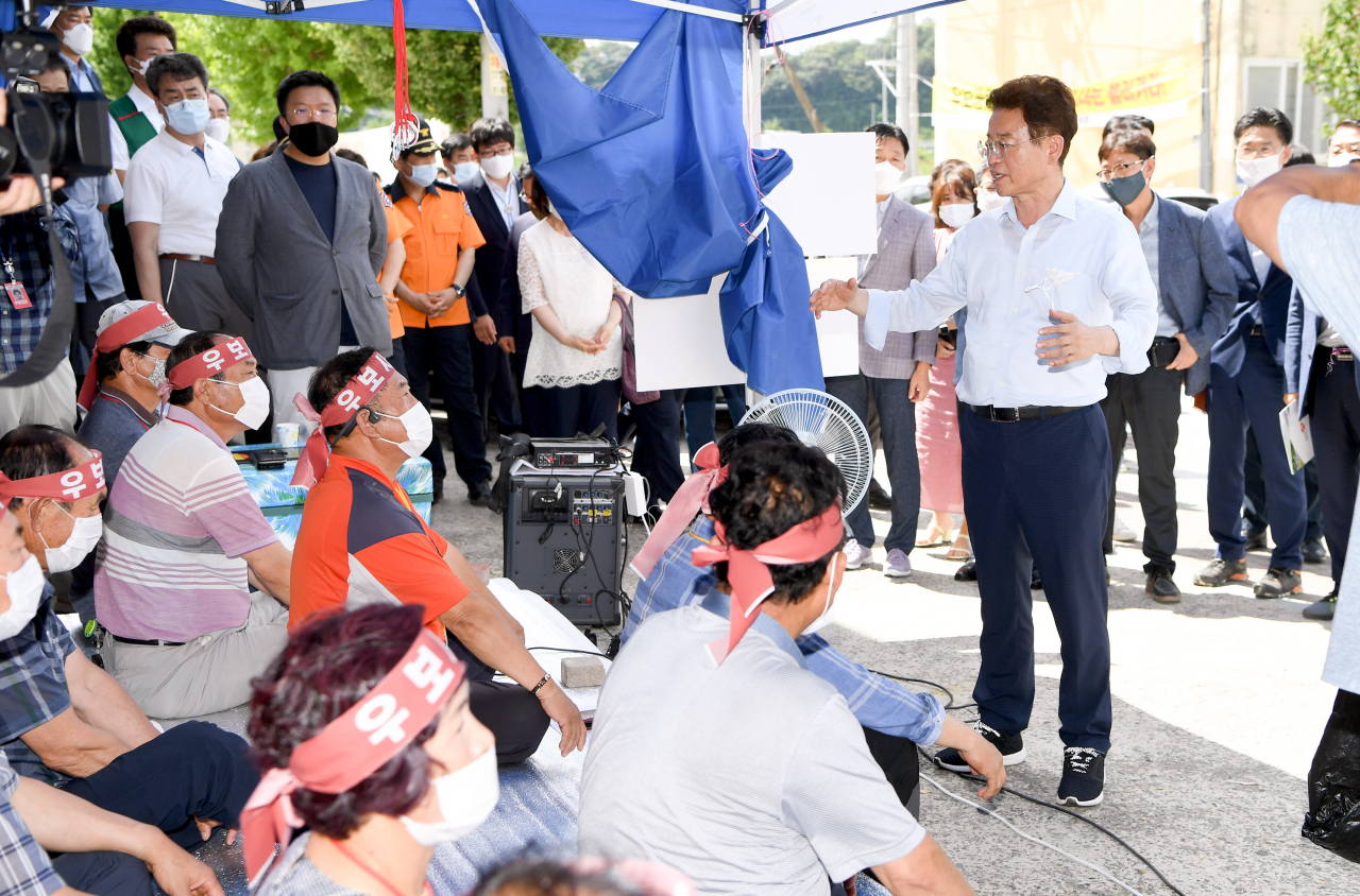 21일 오후 이철우 경북지사가 ‘군위 단독후보지 유치신청’을 요구하며 군위현장사무실 입구에서 농성중인 군위군신공항추진위와 대화를 나누고 있다.[경북도 제공]