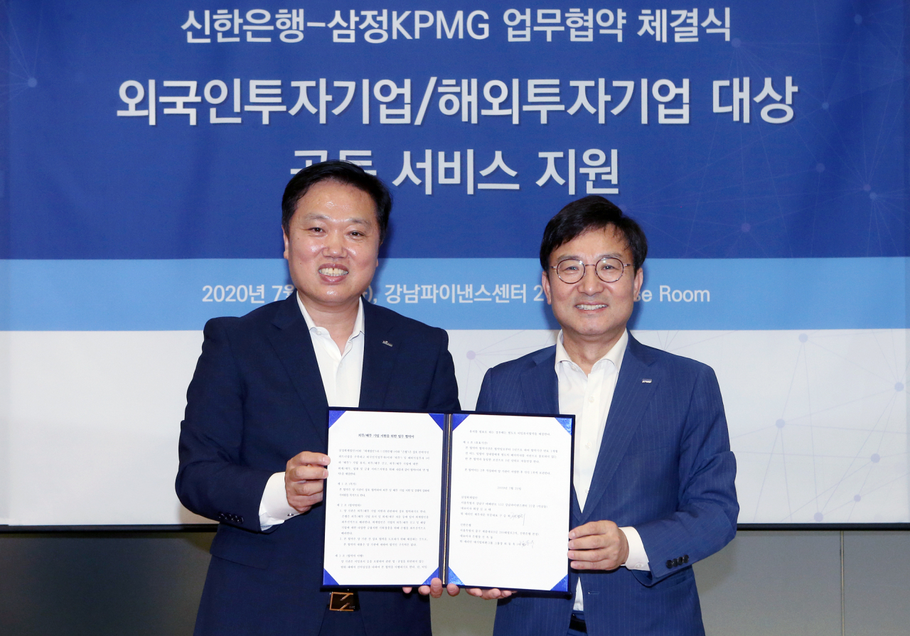 지난 21일 서울시 강남구에 위치한 삼정KPMG 본사 사옥에서 가진 ‘외국인투자기업·해외투자기업 서비스 지원 업무협약’을 마치고 최동욱 신한은행 대기업외환그룹장(왼쪽)과 구승회 삼정KPMG 재무자문부문 대표(오른쪽)가 기념촬영하는 모습. [신한은행 제공]