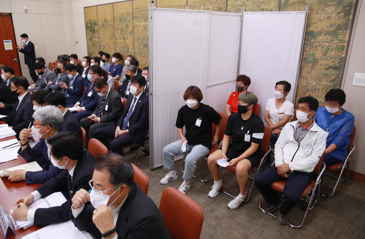22일 국회 문화체육관광위원회에서 열린 '철인 3종경기 선수 가혹행위 및 체육분야 인권침해에 대한 청문회'에 고 최숙현 선수 부모와 동료 선수, 동료 선수 부모 등이 참석해 있다. [연합]