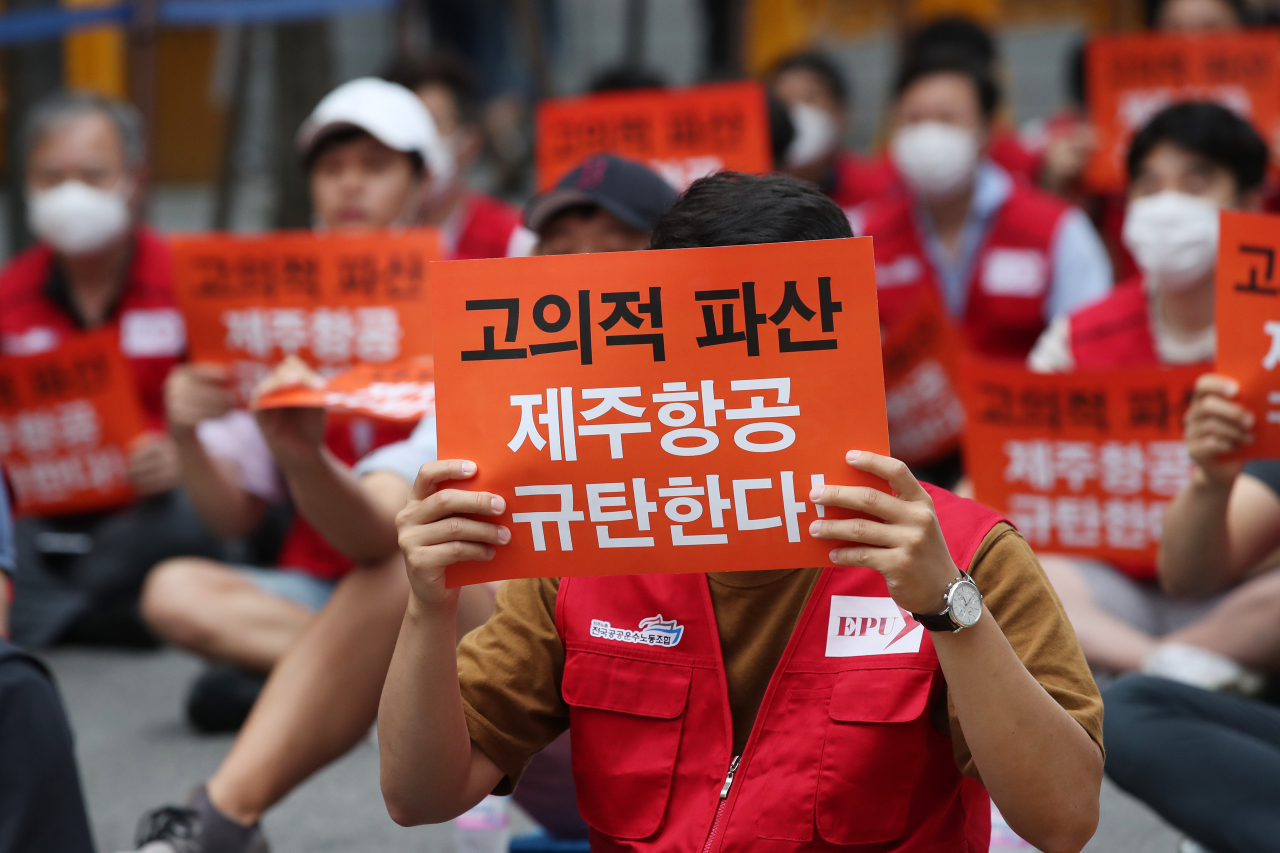 제주항공이 이스타항공 인수를 공식 포기하면서 양사 간 치열한 법정공방이 예상된다. 지난 20일 오후 서울 마포구 애경본사 앞에서 열린 '이스타항공 노동자 8차 총력결의대회'에서 참석자들이 정부의 적극 해결을 촉구하는 손팻말을 들고 있다. [연합뉴스]