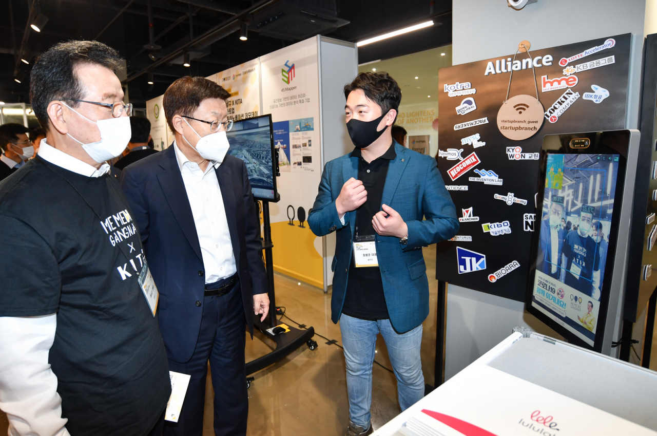 한국무역협회와 강남구는 지난 23일 삼성동 코엑스에서 강남구의 행정·서비스를 혁신할 ‘스타트업 오픈이노베이션 데모데이’를 개최했다. 무역협회 김영주 회장은 이날 강남구 정순균 구청장과 함께 열화상 측정 키오스크 앞에서 스타트업 관계자의 설명을 듣고 있다. [한국무역협회 제공]
