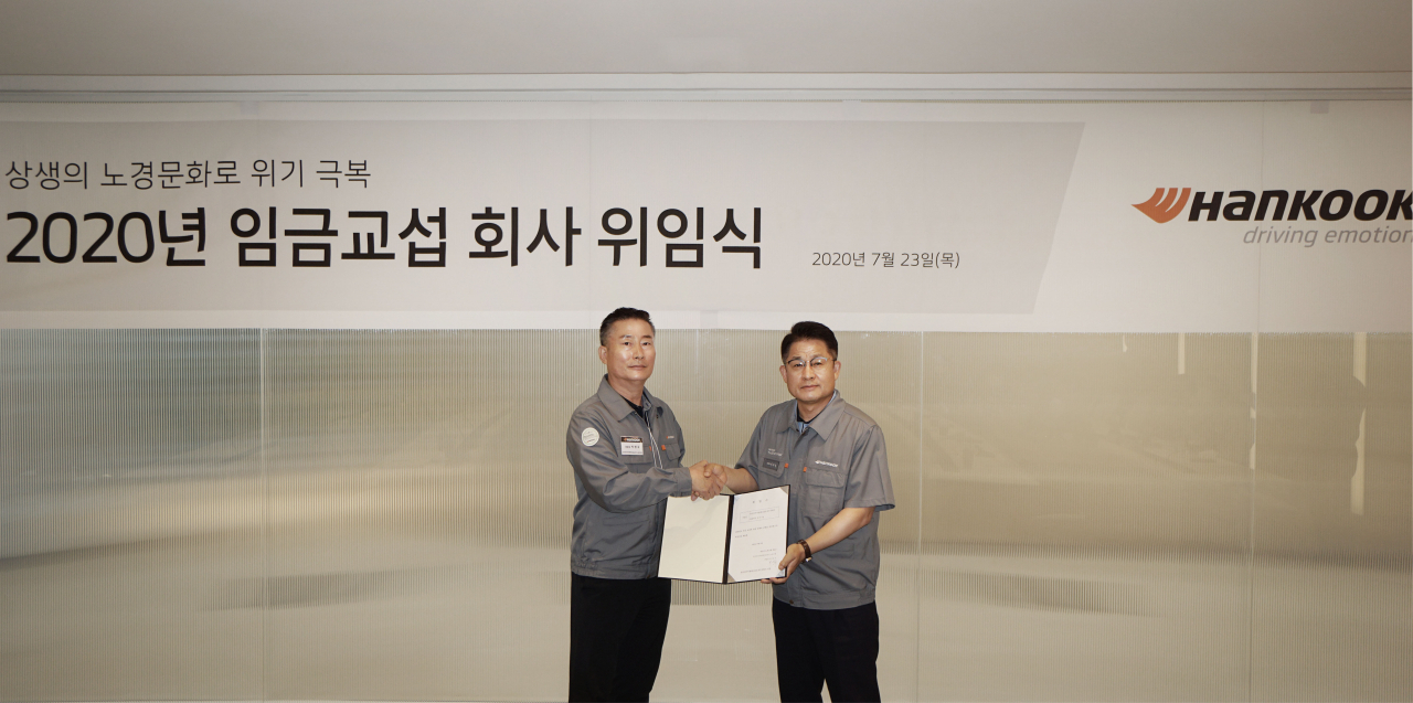 한국타이어앤테크놀로지 COO(최고운영책임자) 이수일 사장(오른쪽)과 한국타이어노동조합 박병국 위원장이 ‘2020년 임금교섭 회사 위임식’에 참여해 기념촬영을 진행하고 있다. [한국타이어 제공]