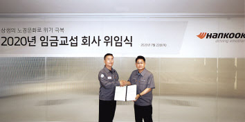 한국타이어앤테크놀로지 COO(최고운영책임자) 이수일(오른쪽) 사장과 한국타이어노동조합 박병국 위원장이 ‘2020년 임금교섭 회사 위임식’에 참여해 기념촬영을 진행하고 있다. [한국타이어 제공]