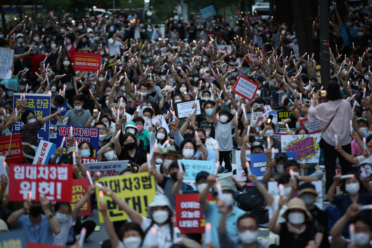 지난 25일 오후 서울 중구 예금보험공사 앞에서 열린 ‘소급적용 남발하는 부동산 규제 정책 반대, 전국민 조세 저항운동 촛불집회’ 참가자들이 촛불을 들고 있다. [연합]