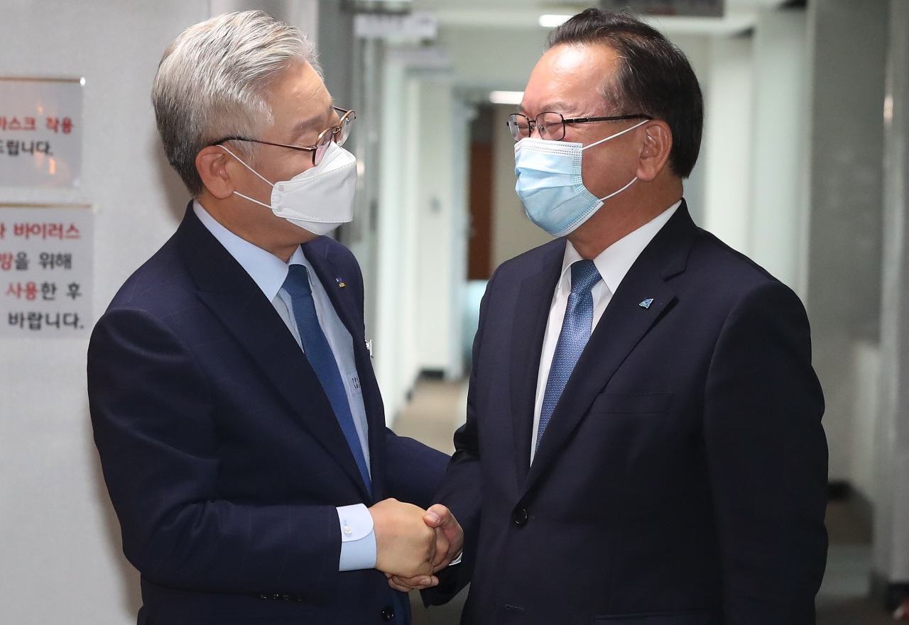 더불어민주당 당 대표에 출마한 김부겸 전 의원이 27일 오전 경기도 수원시 경기도청에서 이재명 경기도지사와 악수를 하고 있다. [연합]