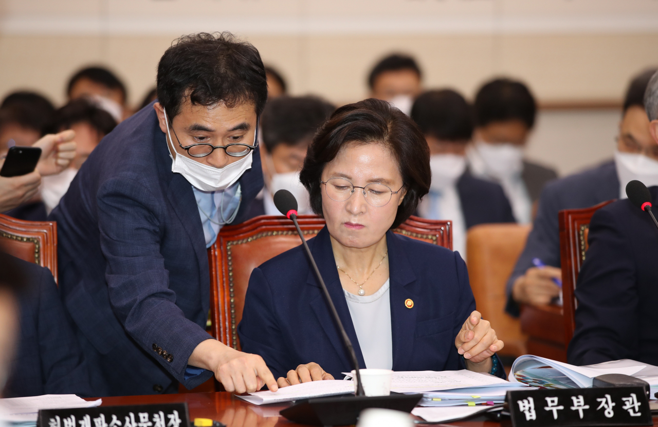 추미애 법무부 장관이 27일 오전 국회 법제사법위원회 전체회의에 참석해 관계자와 대화하고 있다. [연합]