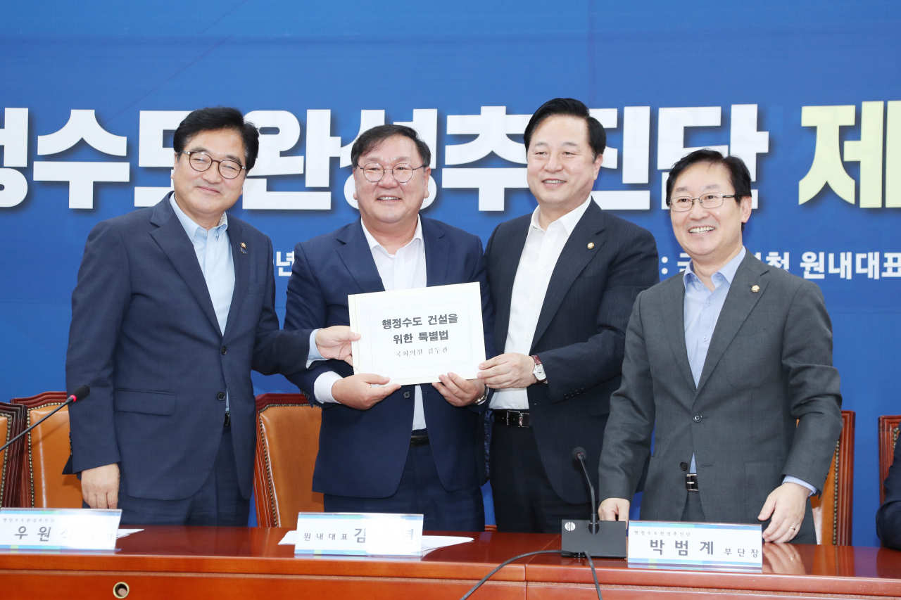 김태년 더불어민주당 원내대표가 27일 오후 서울 영등포구 국회에서 열린 행정수도 완성추진단 1차 회의에서 김두관 의원에게 행정수도 건설을 위한 특별법을 전달받고 있다. 왼쪽부터 더불어민주당 우원식 의원, 김 원내대표, 김 의원, 박범계 의원. [연합]