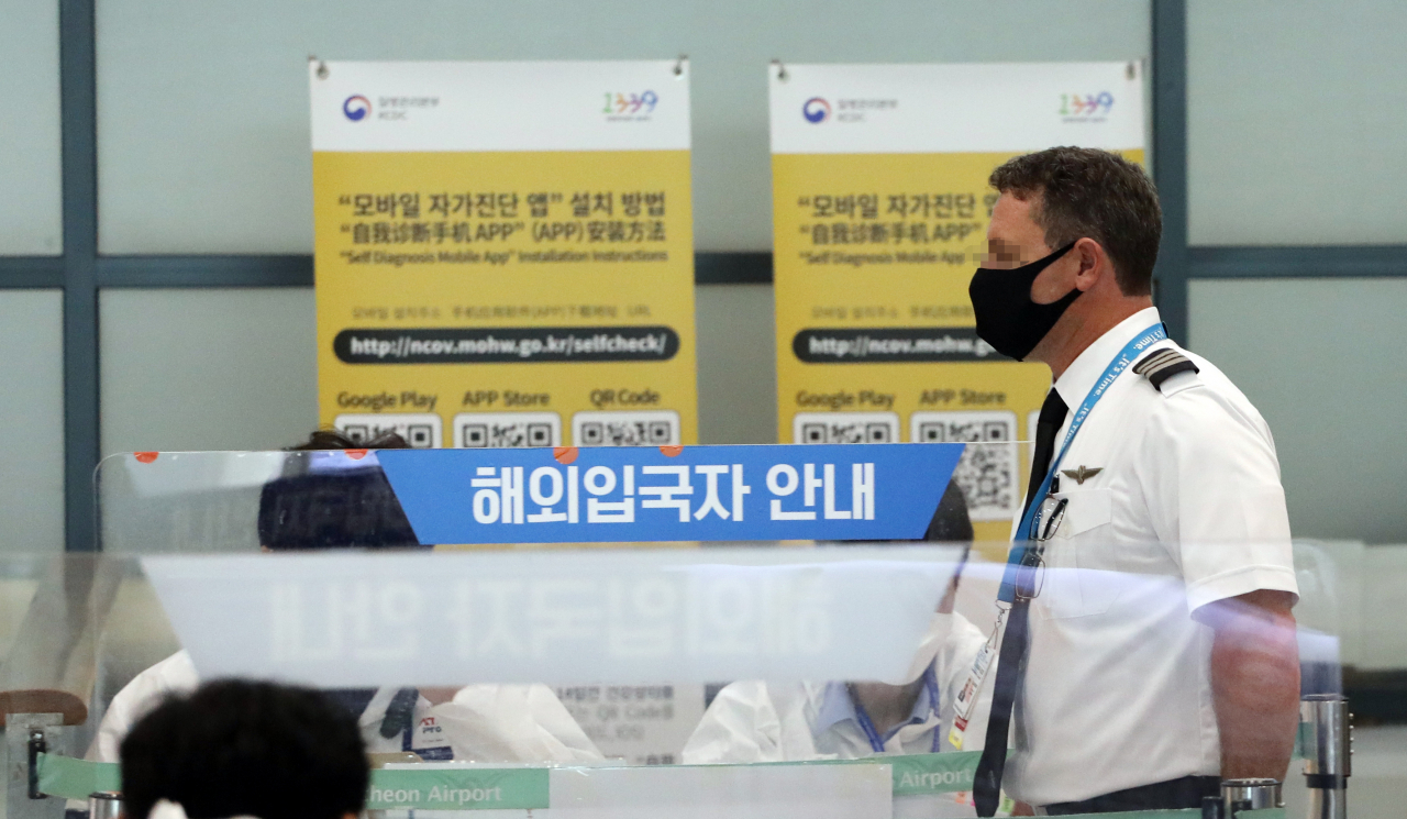 27일 오후 인천국제공항에서 항공사 관계자들이 입국장을 나오고 있다. 정부는 코로나19 해외유입 외국인 확진자에게 치료비를 부과할 수 있도록 법 개정을 추진하기로 했다. [연합]
