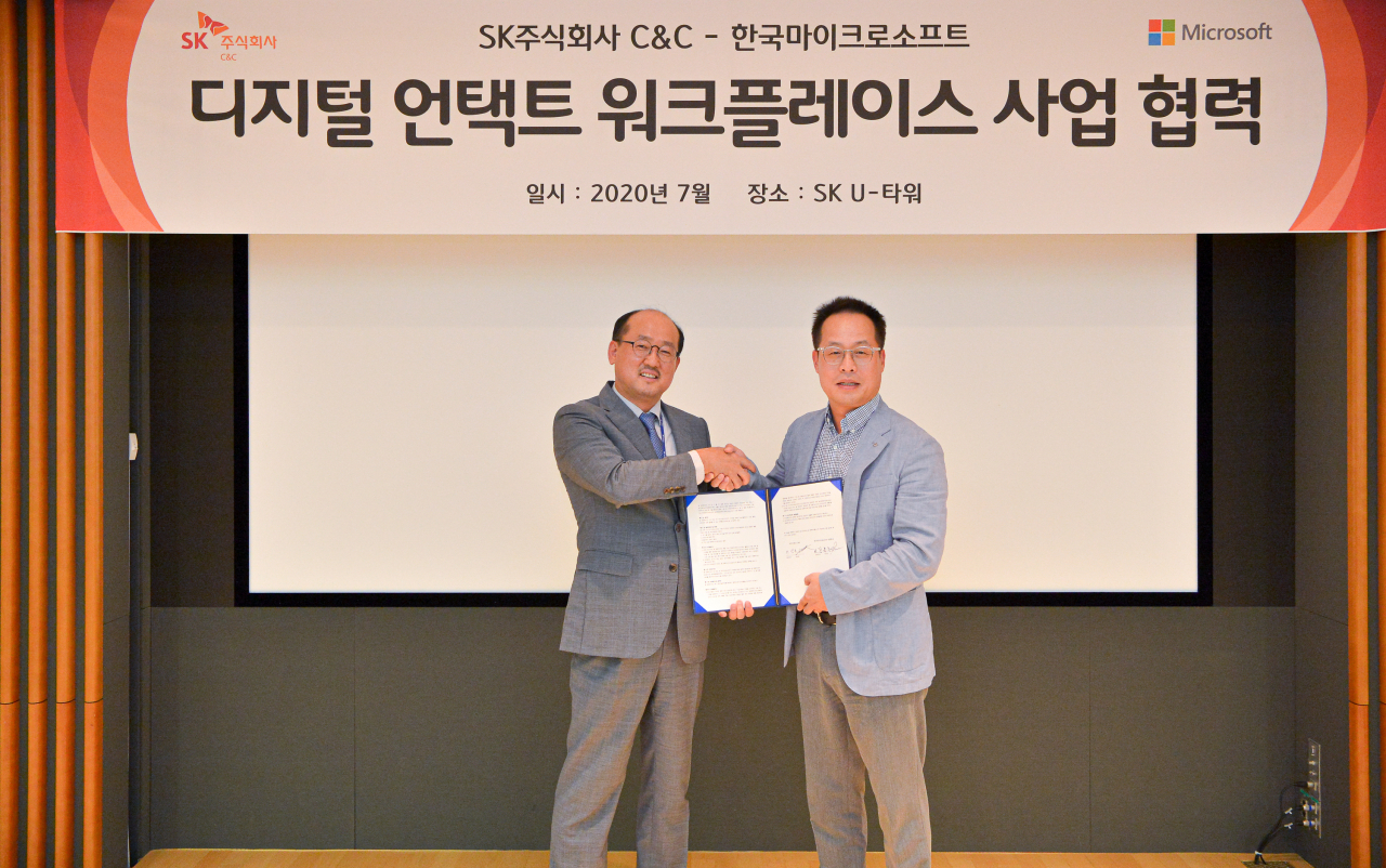 28일 경기도 성남 분당 사옥에서 SK(주) C&C 이상국 통신서비스 디지털 부문장(오른쪽)과 한국마이크로소프트 장홍국 OCP 부문장이 기념촬영을 하는 모습 [SK주) C&C 제공]