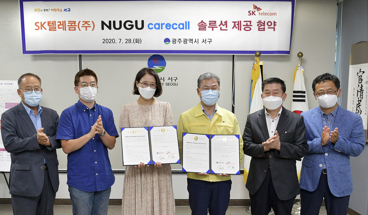 사진은 지난 28일 이현아 SK텔레콤 AI서비스단장(좌측)과 서대석 서구청장이 '누구 케어콜'의 광주광역시 서구 도입 협약을 맺은 모습. [SK텔레콤 제공]