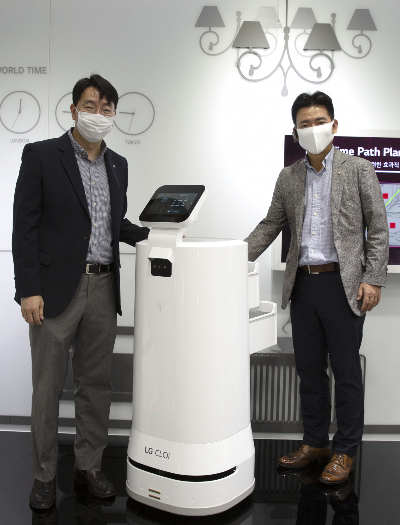 김성기 GS리테일 상무(사진 왼쪽)와 정원진 LG전자 상무가 GS25의 배송을 책임질 인공지능(AI) 로봇을 사이에 두고 포즈를 취하고 있다. [사진제공=GS리테일]