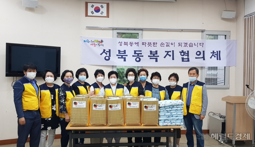 성북동 복지협의체 위원들이 14일 소외계층에 보낼 여름이불을 포장한 뒤 기념촬영을 하고 있다. [성북구 제공]